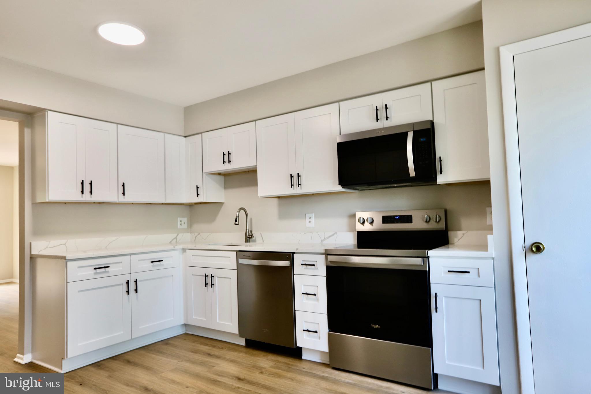 7442 Broken Staff Columbia, MD 21045 - Photo 6 of 28 a kitchen with stainless steel appliances a stove microwave and cabinets