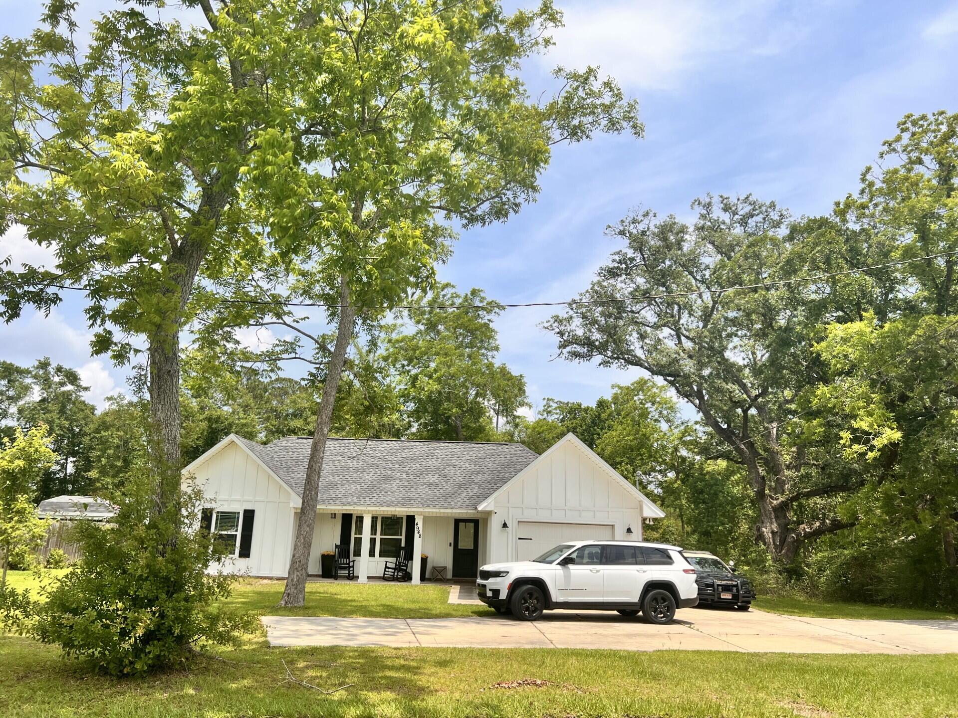 a white house covered with tall trees