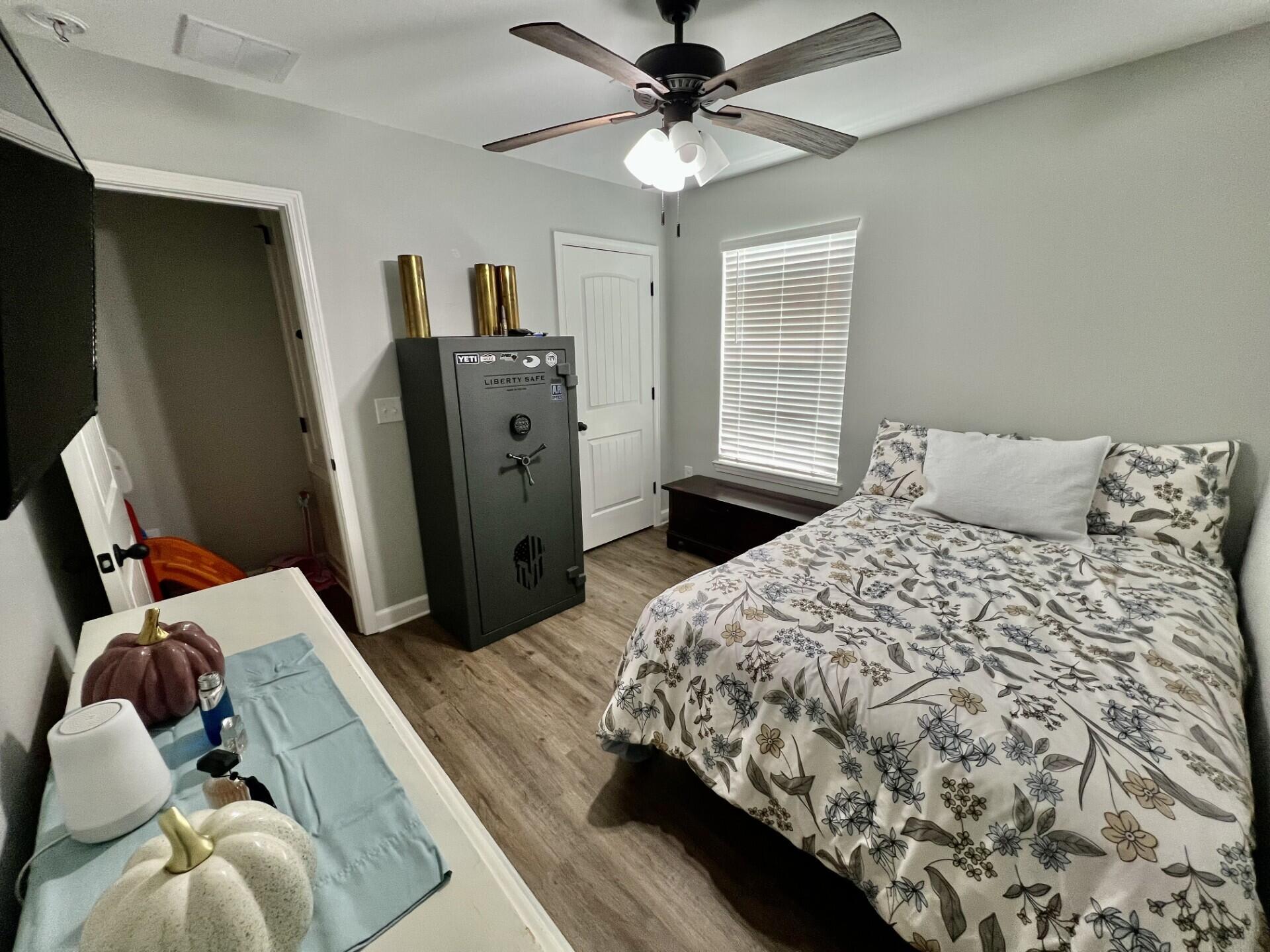 4948 Guernsey Road Pace, FL 32571 - Photo 12 of 25 a bedroom with a bed and wooden floor