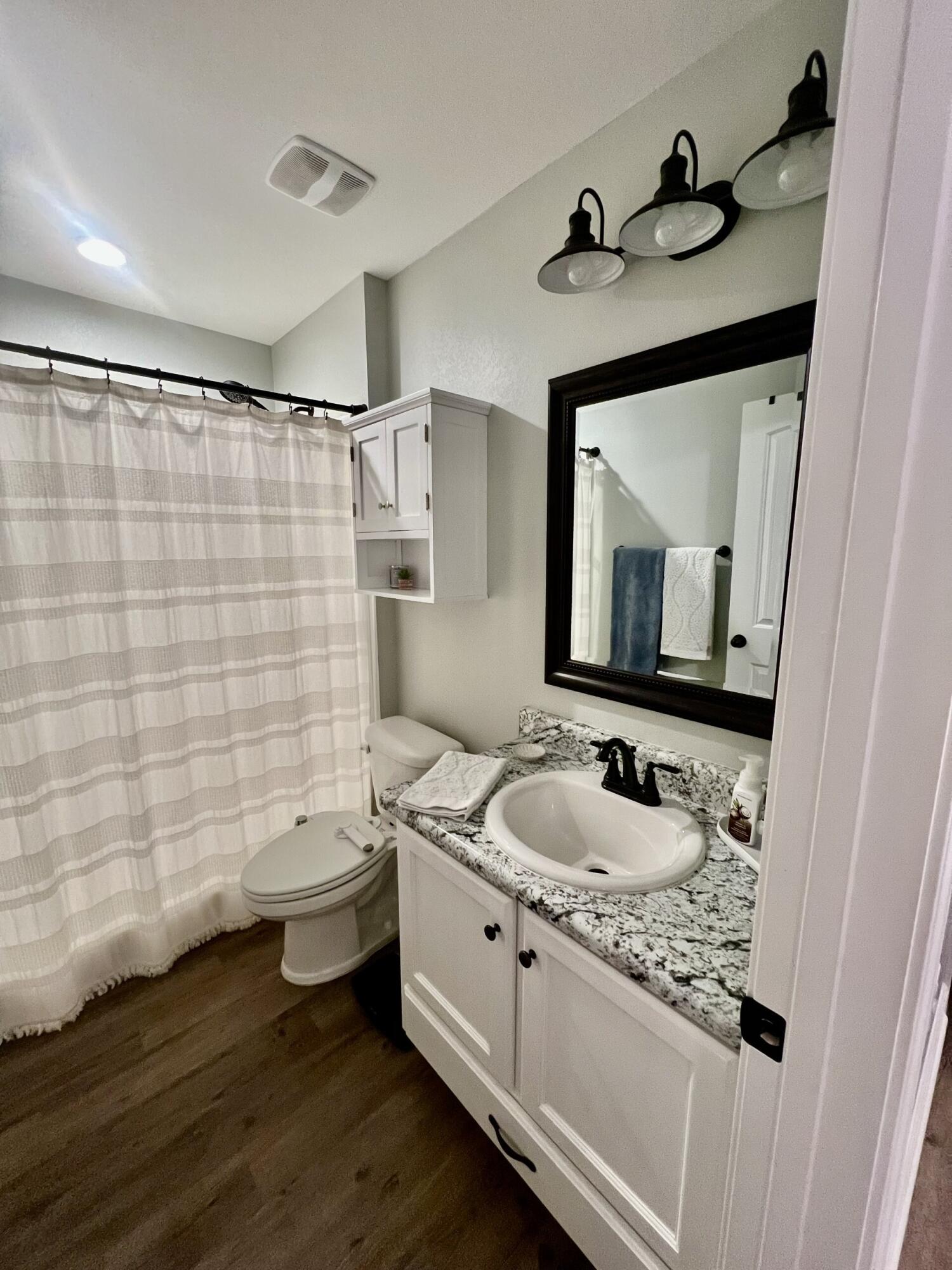 4948 Guernsey Road Pace, FL 32571 - Photo 19 of 25 a bathroom with a granite countertop toilet sink and mirror
