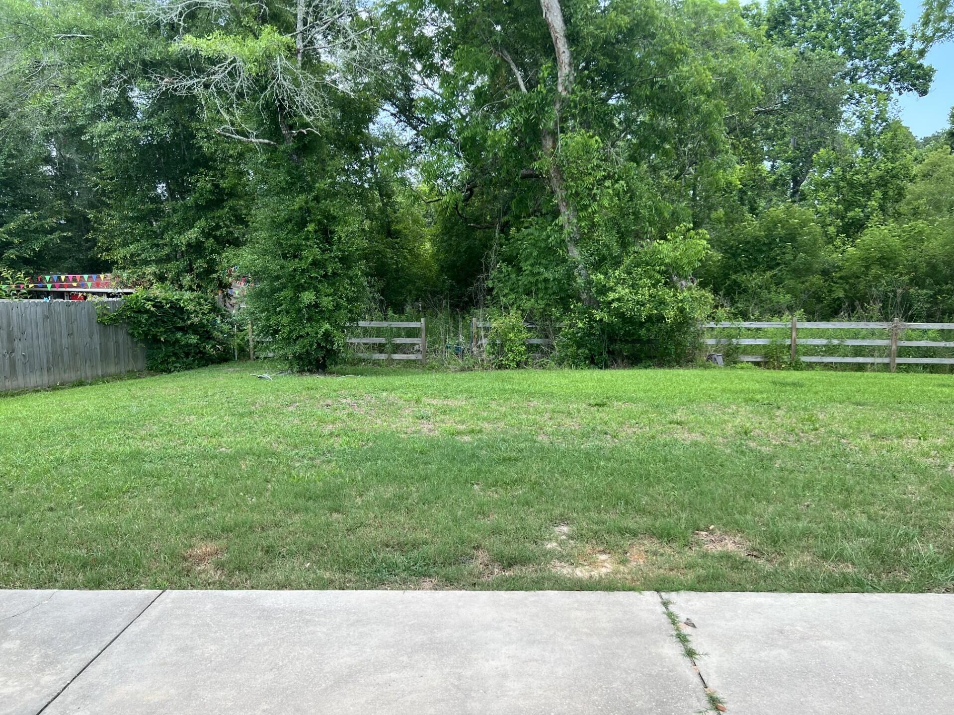 4948 Guernsey Road Pace, FL 32571 - Photo 25 of 25 a backyard of a house with lots of green space