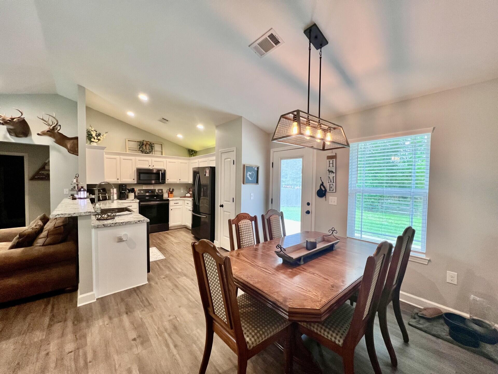 4948 Guernsey Road Pace, FL 32571 - Photo 4 of 25 a view of a dining room with furniture window and wooden floor