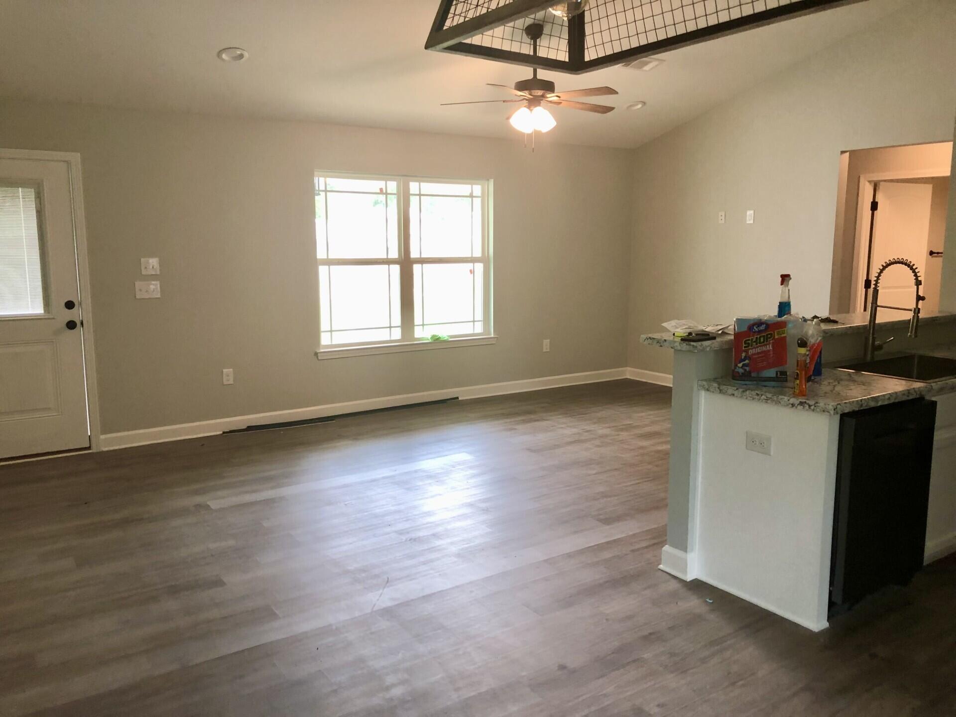 4948 Guernsey Road Pace, FL 32571 - Photo 8 of 25 an empty room with wooden floor fan and windows
