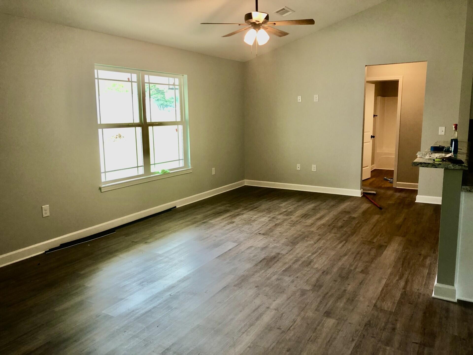 4948 Guernsey Road Pace, FL 32571 - Photo 9 of 25 a view of an empty room with wooden floor and a window