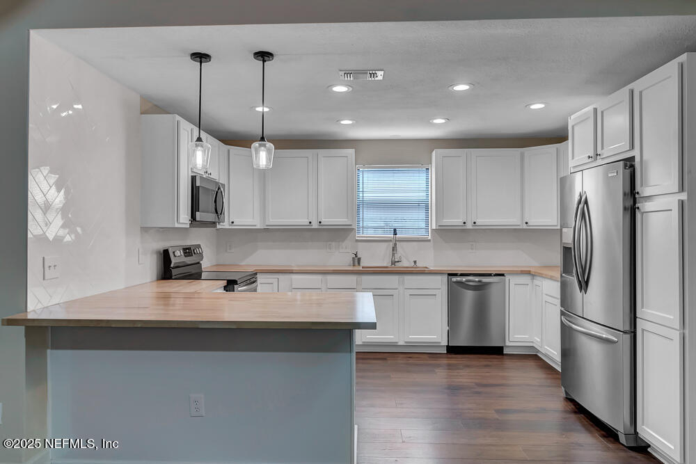4518 Crosstie Road South Jacksonville, FL 32257 - Photo 11 of 28 a kitchen with stainless steel appliances granite countertop a sink a stove a refrigerator and island with wooden floor