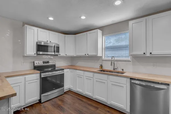 a kitchen with sink a microwave and cabinets
