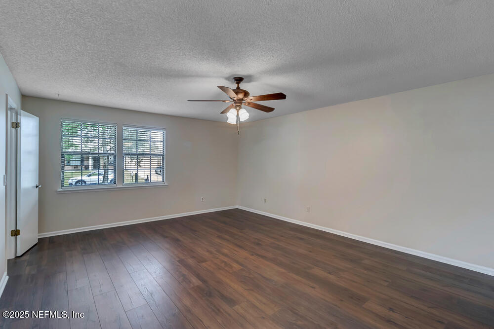 4518 Crosstie Road South Jacksonville, FL 32257 - Photo 16 of 28 an empty room with wooden floor fan and windows