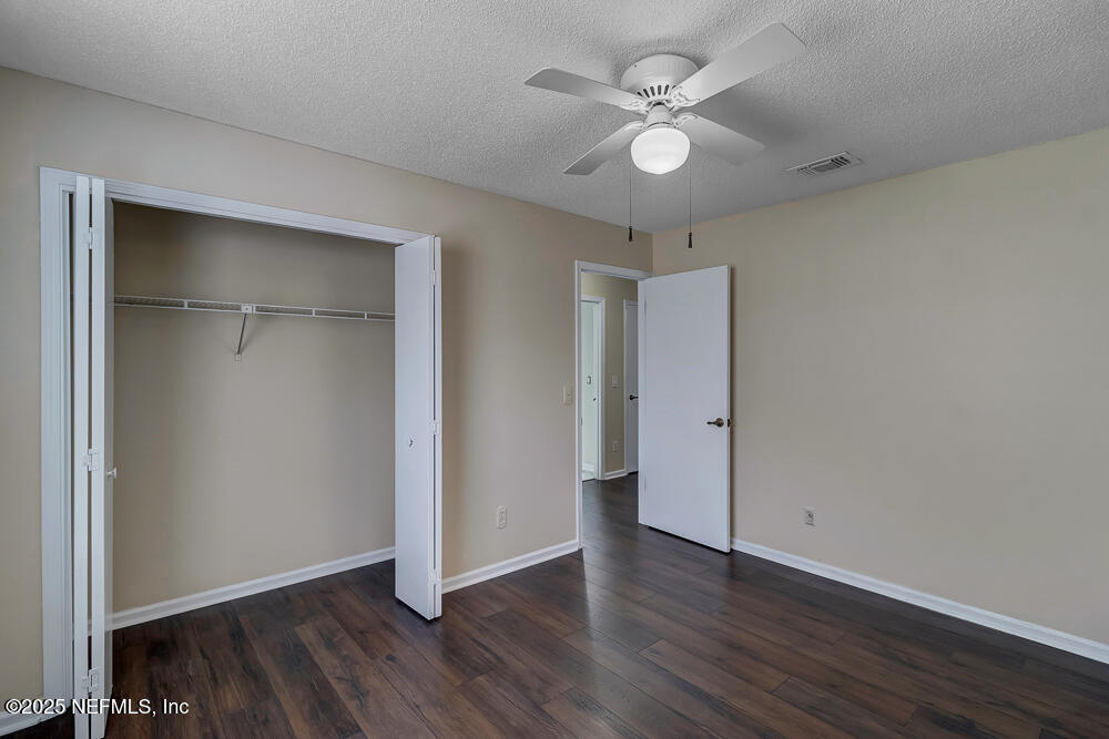 4518 Crosstie Road South Jacksonville, FL 32257 - Photo 21 of 28 an empty room with wooden floor and ceiling fan