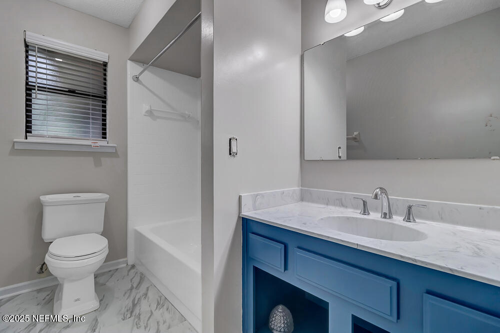4518 Crosstie Road South Jacksonville, FL 32257 - Photo 22 of 28 a bathroom with a toilet a sink and mirror