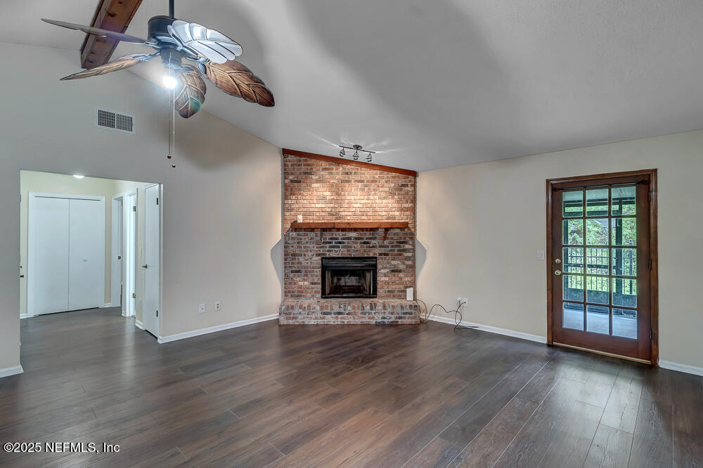 4518 Crosstie Road South Jacksonville, FL 32257 - Photo 9 of 28 a view of an empty room with wooden floor fireplace and a window
