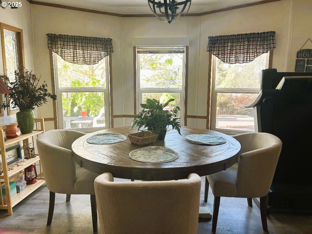 96465 Coverdell Road, Unit 20 Brookings, OR 97415 - Photo 5 of 21 a dining room with furniture a chandelier and wooden floor