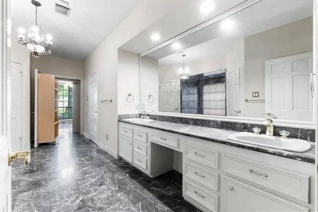 a spacious bathroom with a granite countertop sink a mirror and a shower