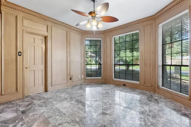 a view of a room with a ceiling fan and window