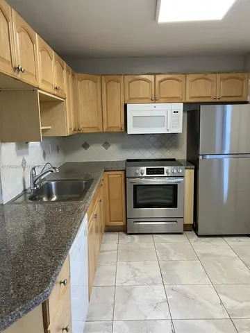 a kitchen with a stove sink and cabinets