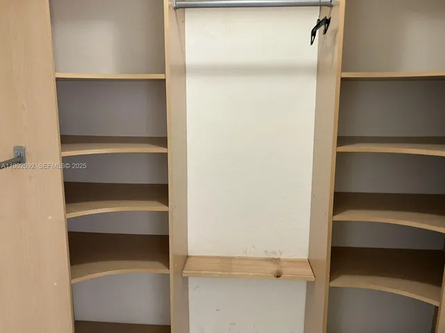 a view of walk in closet with empty racks