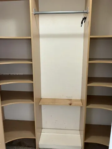 a view of walk in closet with empty racks
