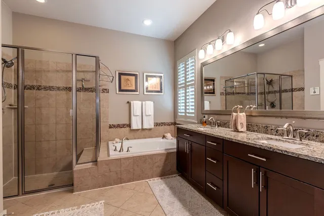 a spacious bathroom with a double vanity sink a large mirror and shower