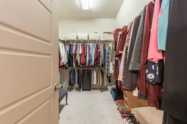a view of walk in closet with clothes