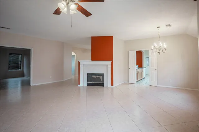 an empty room with fan and fireplace