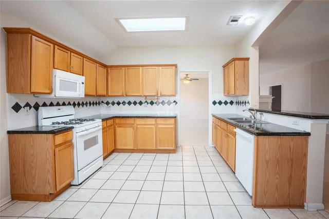 a kitchen with stainless steel appliances granite countertop a sink stove and cabinets