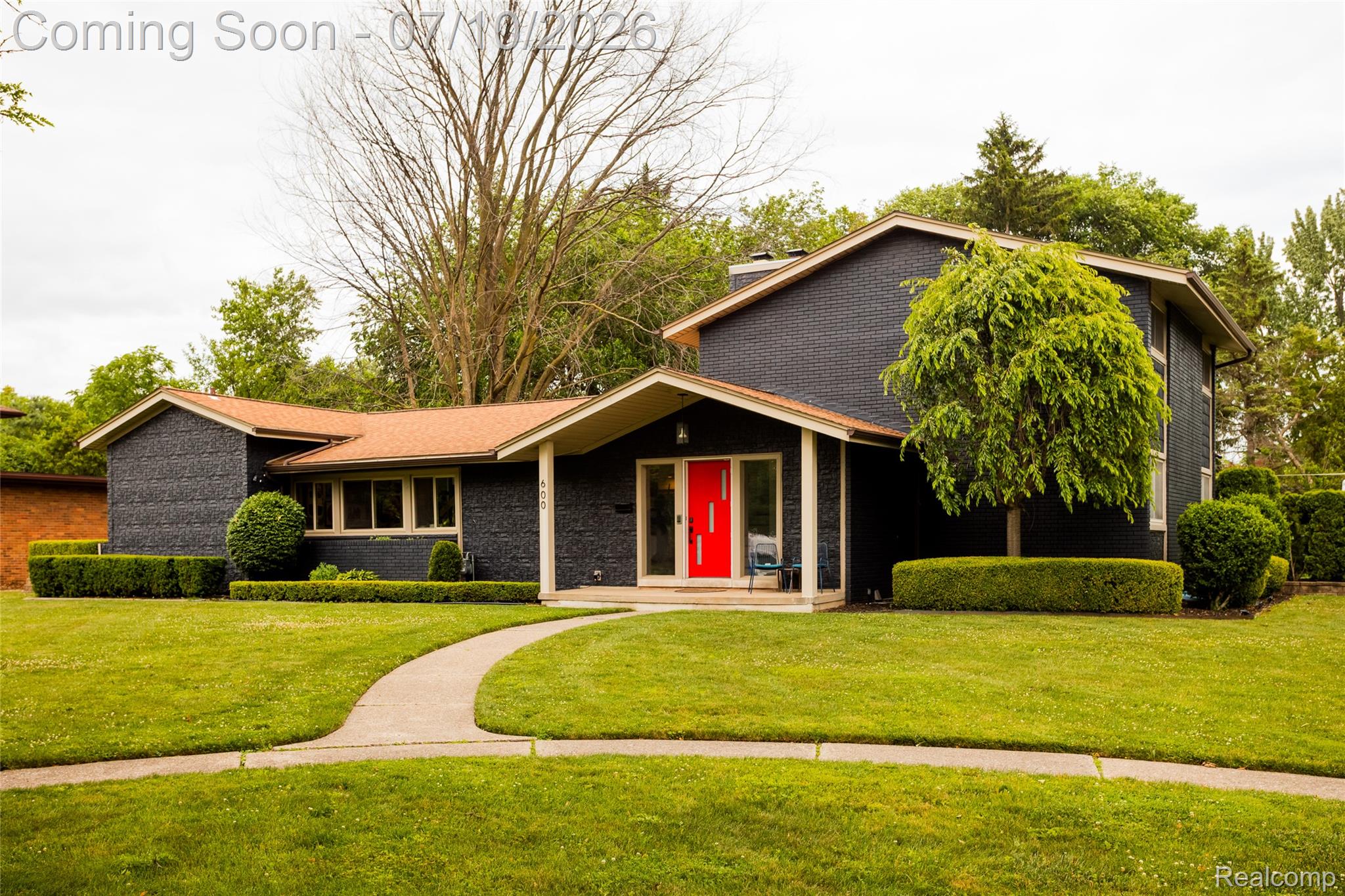 600 Middlesex Road Grosse Pointe, MI 48230 - Photo 1 of 43 Black brick exterior featuring an exposed aggregate walkway, contrasting red front door, and a brown shingle roof
