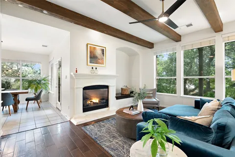 a living room with furniture a fireplace and a large window