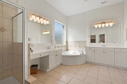 a large bathroom with a double vanity sink mirror and bathtub