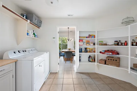 a storage utility room with a lot of cabinets and wooden floor