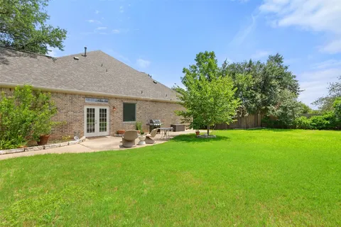a front view of a house with backyard garden and sitting area
