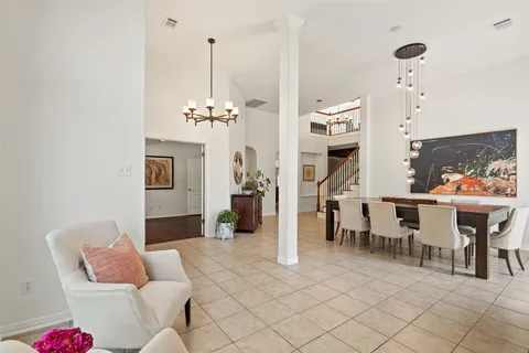 a living room with furniture a dining table and a chandelier