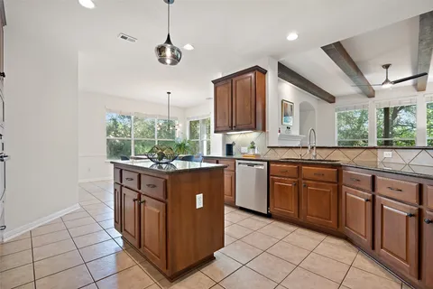 a kitchen with stainless steel appliances granite countertop a stove a sink and a refrigerator