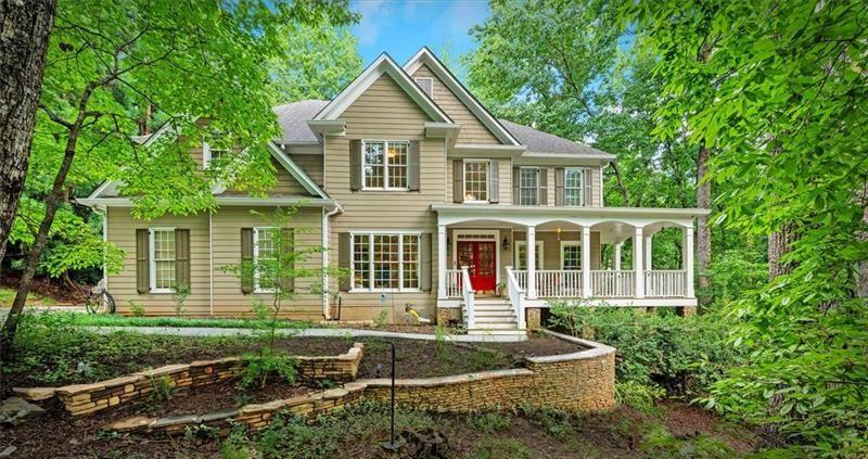 a front view of a house with a yard and potted plants