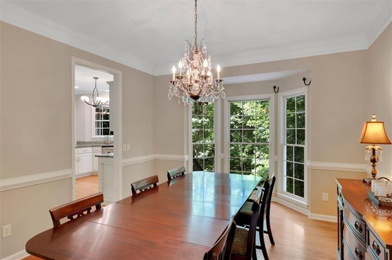 1170 Spring Oak Way Cumming, GA 30041 - Photo 15 of 77 a dining room with furniture a chandelier and wooden floor