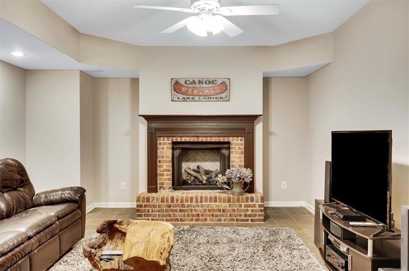 1170 Spring Oak Way Cumming, GA 30041 - Photo 49 of 77 a living room with furniture a flat screen tv and a fireplace