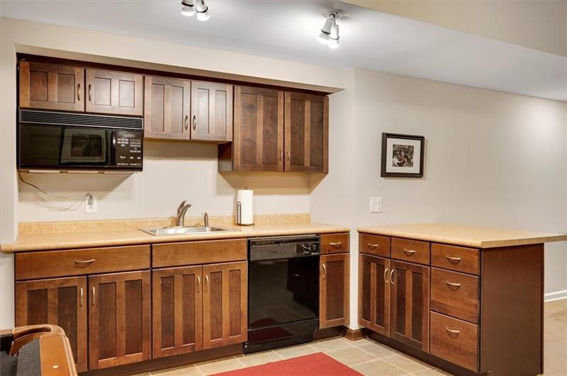 1170 Spring Oak Way Cumming, GA 30041 - Photo 51 of 77 a kitchen with stainless steel appliances granite countertop a stove a sink dishwasher and a microwave oven with wooden cabinets