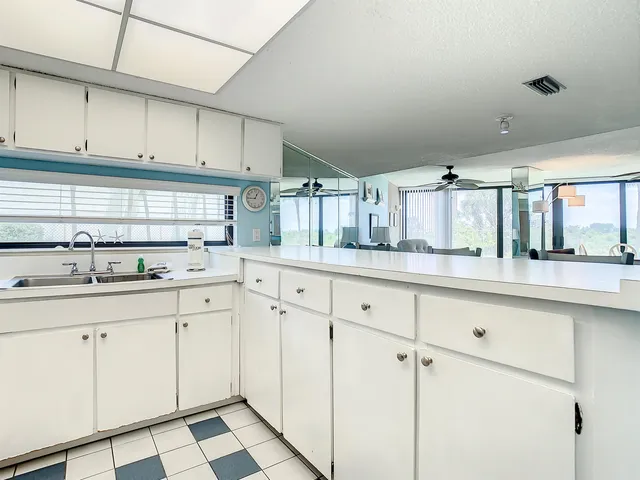 a kitchen with white cabinets sink and white appliances