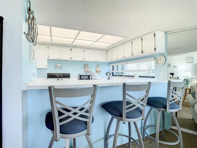 a kitchen with stainless steel appliances a dining table chairs and a refrigerator