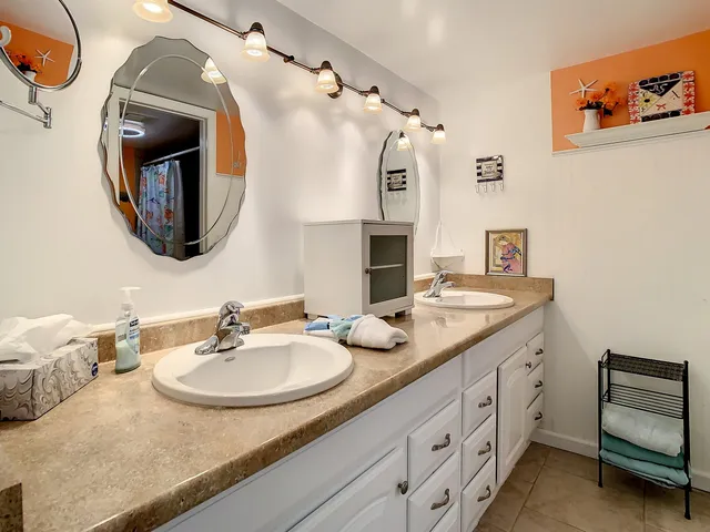 a en suite bathroom with a double vanity sink and a mirror