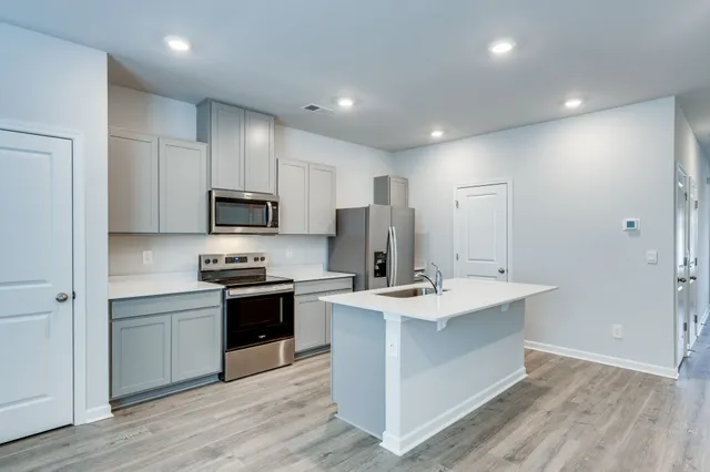 a kitchen with stainless steel appliances a sink stove and refrigerator
