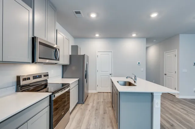 a kitchen with stainless steel appliances granite countertop a sink stove and refrigerator