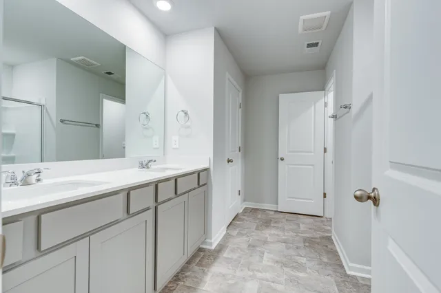 a spacious bathroom with a double vanity sink mirror and double
