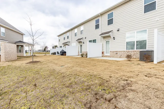 a view of a large white house with a yard