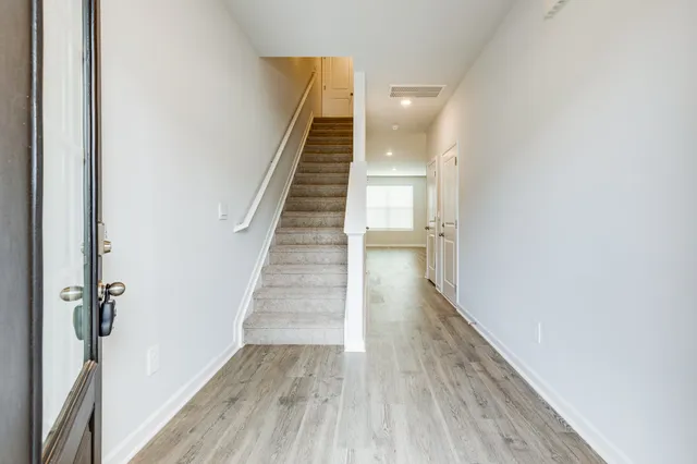 a view of a hallway with wooden floor and staircase