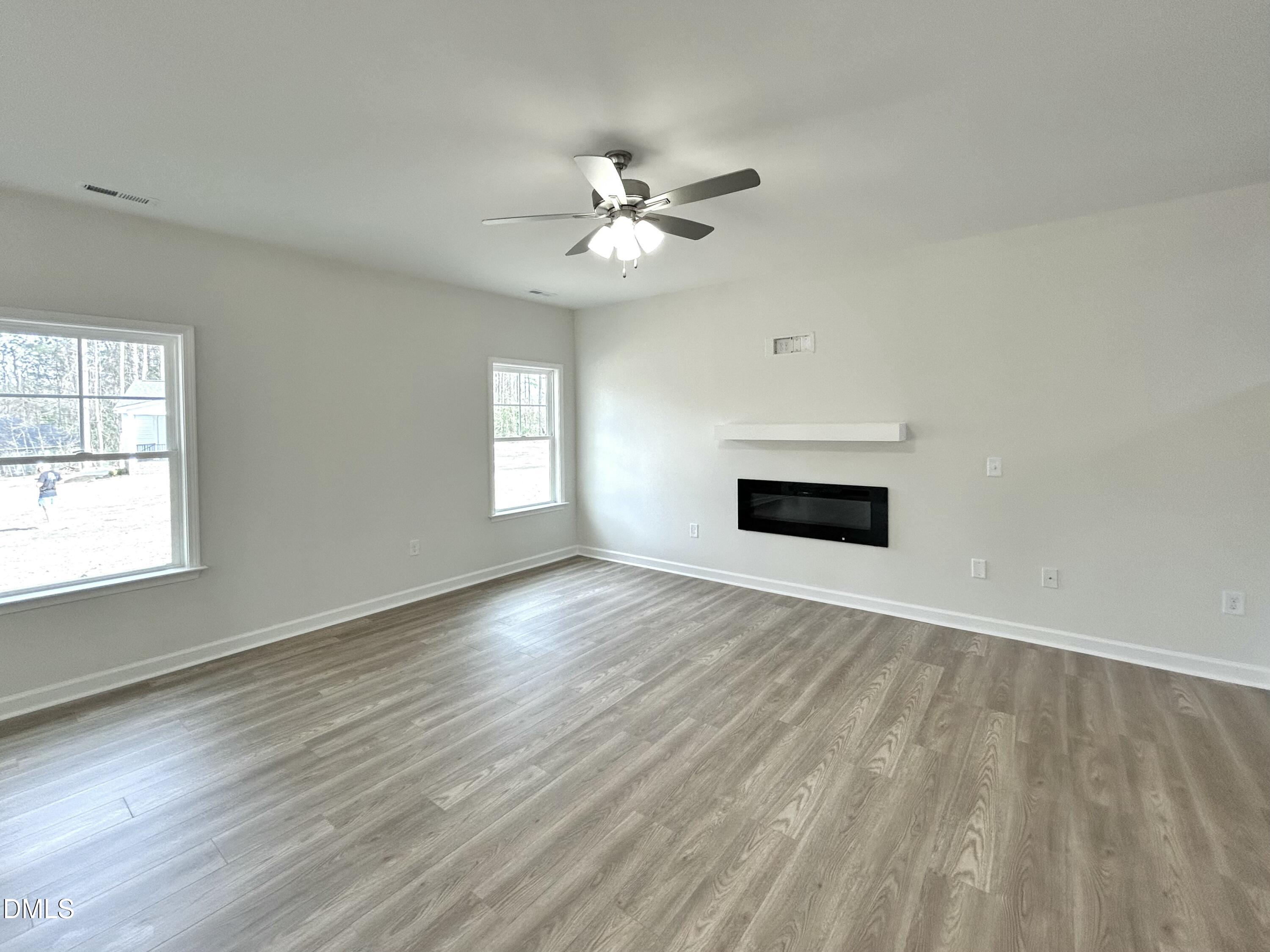 1739 Cardinal Drive Deep Run, NC 28525 - Photo 16 of 29 an empty room with wooden floor chandelier fan and windows