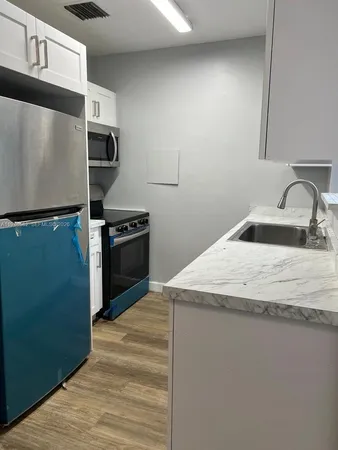 a kitchen with granite countertop a sink and a stove top oven