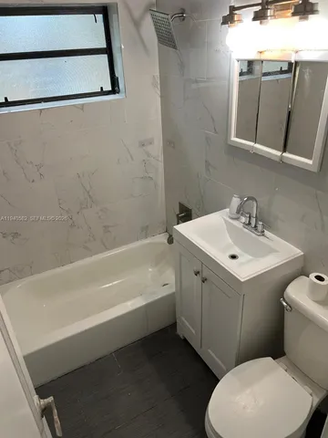 a bathroom with a sink mirror vanity and toilet
