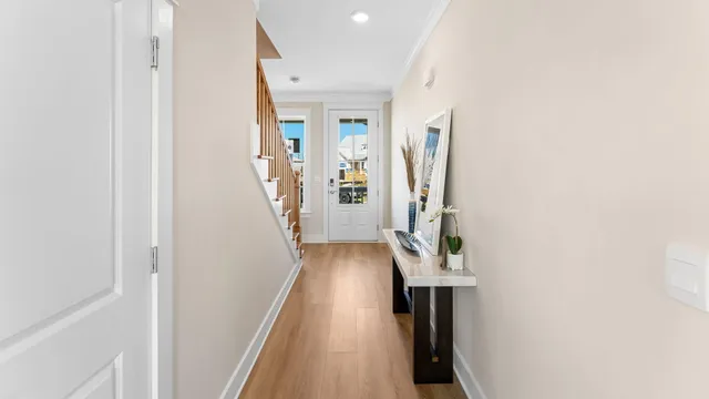 a view of a hallway with wooden floor and stairs