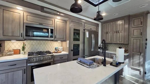 a kitchen with stainless steel appliances granite countertop a stove and a microwave