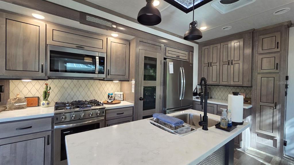 561 Waterway Drive River Ranch, FL 33867 - Photo 12 of 18 a kitchen with stainless steel appliances granite countertop a stove and a microwave