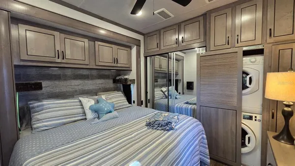 a bedroom with a bed next to a ceiling fan